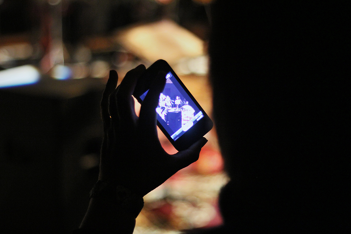 Aaron Adair live at the Refinery in Saskatoon. An audience member shoots a video of the show on her smartphone. Photo taken Friday, April 12, 2013.