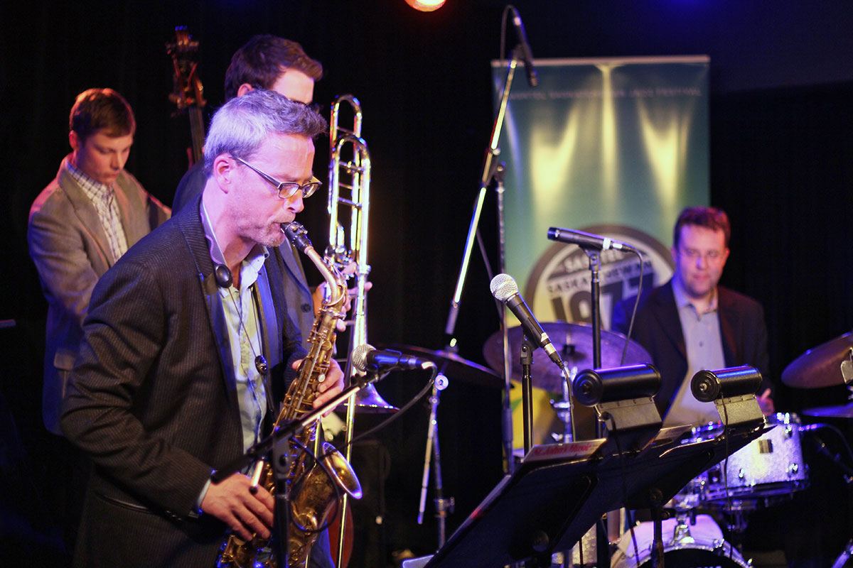 The Story of Jazz. Mark DeJong taking a solo, baked up by Soren Nissen on the bass and Jon McCaslin at the kit. Photo taken Tuesday, April 30, 2013.
