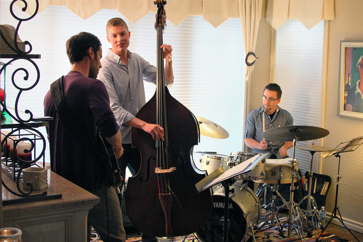The Soren Nissen, Ian Wright and Nate Renner trio. The trio began playing as the last bit of sunlight was diffused into the living room. Photo taken Friday, May 17, 2013.